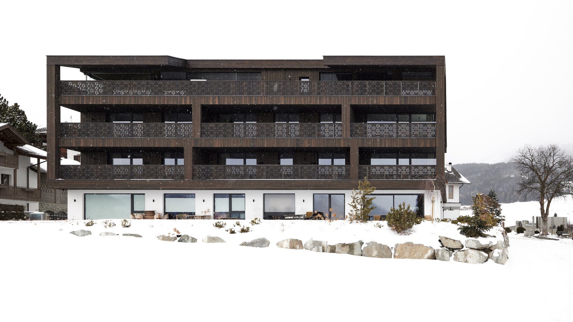 Beispielaufbau einer Unterseite Modern dark wood chalet with balcony in snowy winter landscape