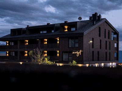 Ferienwohnung im Pustertal? Jetzt anfragen und los geht’s! ☎ Beleuchtete Berghütte bei Dämmerung mit bewölktem Himmel